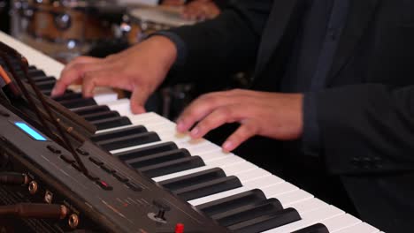 the hands of a musician man playing the electronic piano during a concert