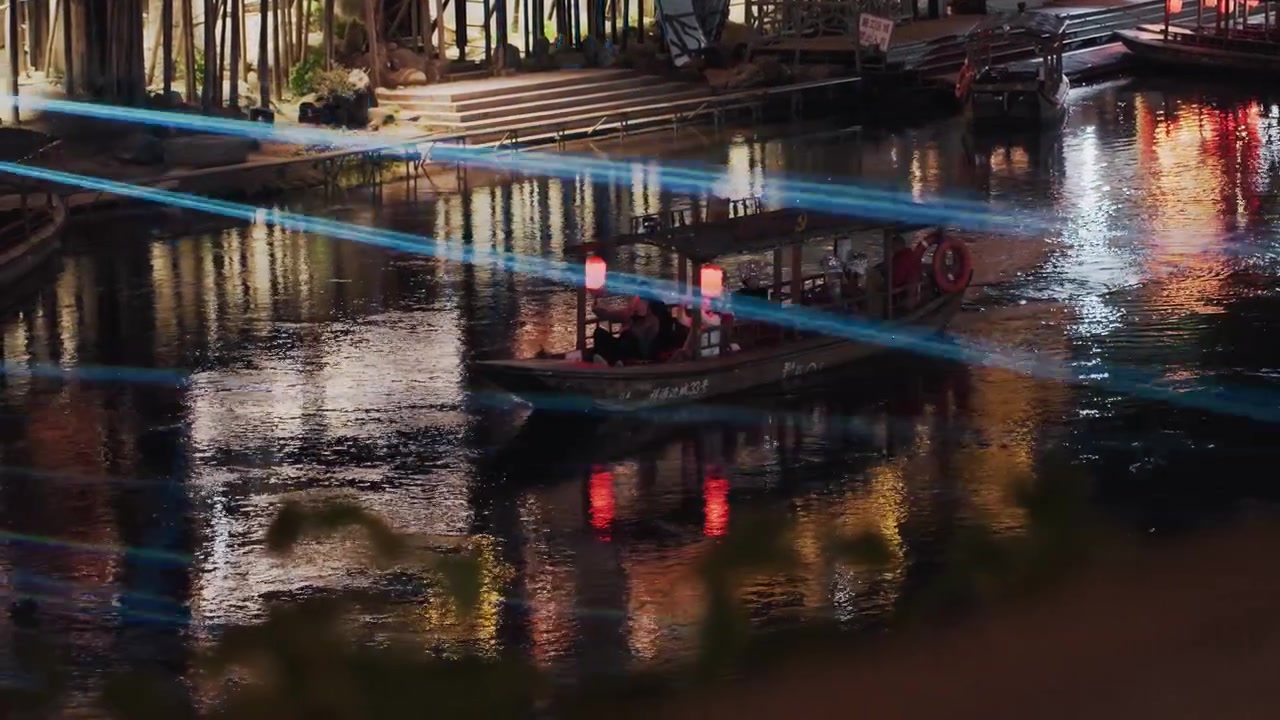 Promenade nocturne au bord de l'eau avec des faisceaux laser, spectacle lumineux dynamique traversant la rivière tandis qu'un bateau transporte des passagers, reflets néon striant l'eau, spectacle urbain moderne avec un guide et une foule enthousiaste