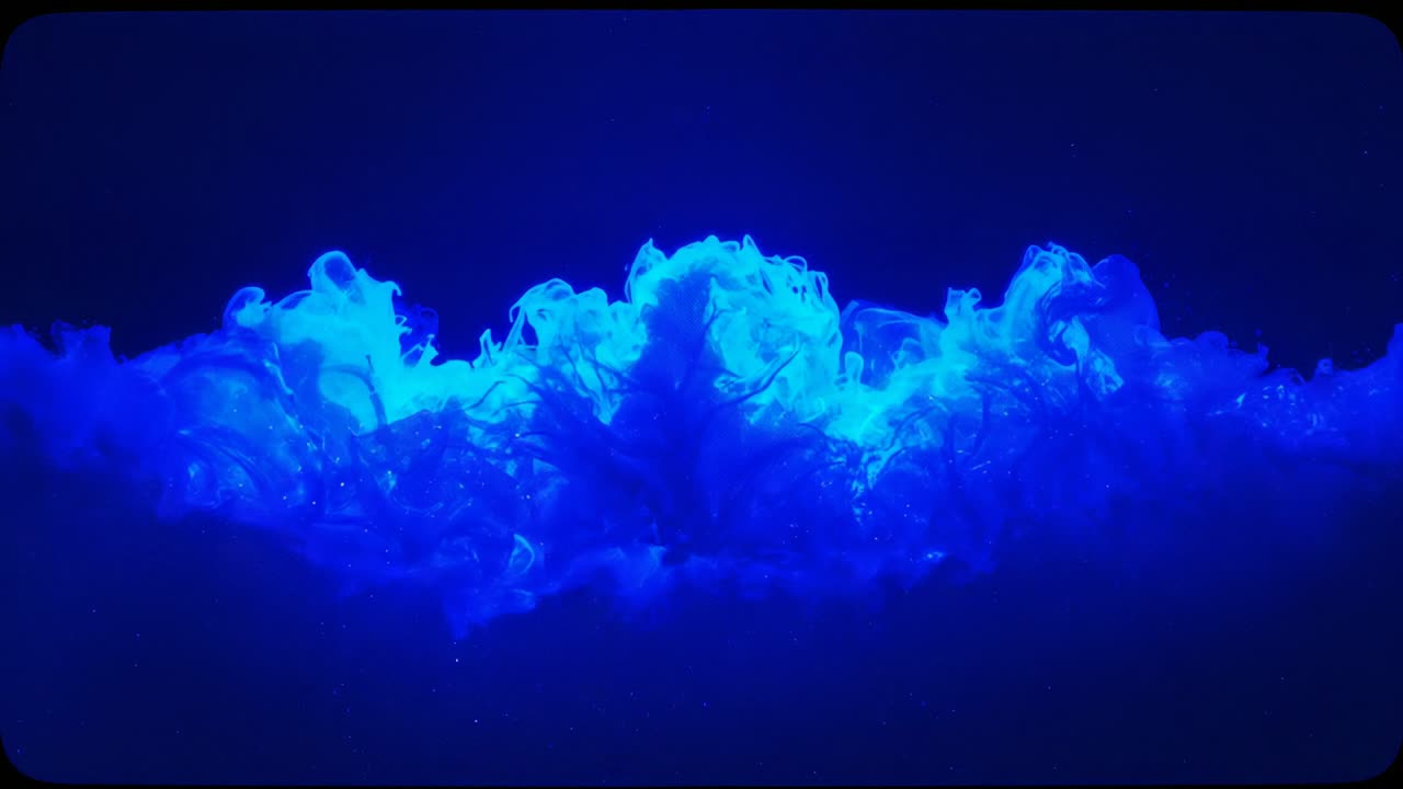 Emerging electric-blue fluid wave rising, undulating within dark sealed tank with glowing droplets