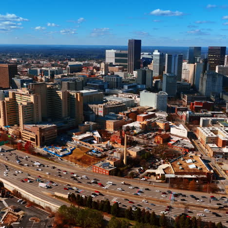 multiple cars in the road going around the city downtown. splendid view of atlanta from aerial perspective.
