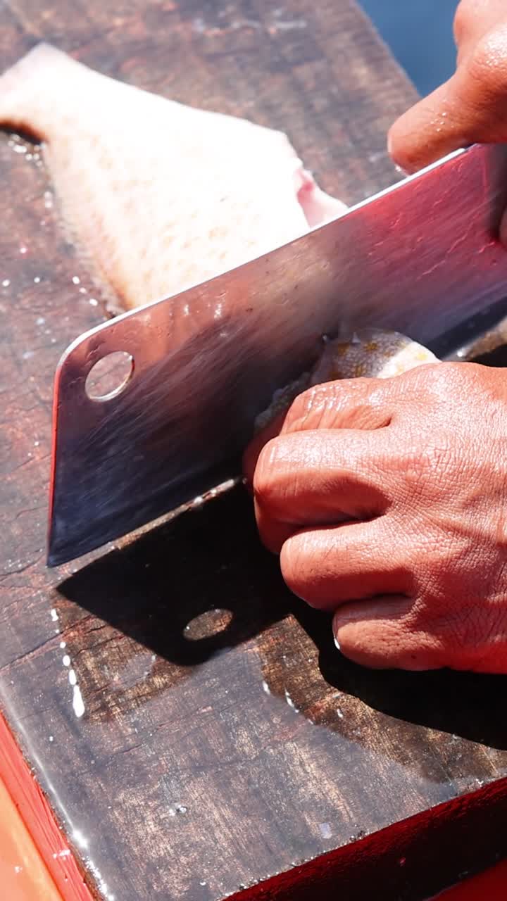 persona fileteando pescado en una tabla de cortar