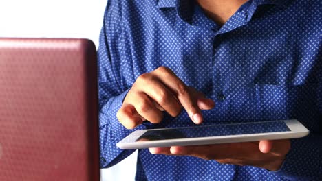 persona que utiliza una computadora portátil y una tableta