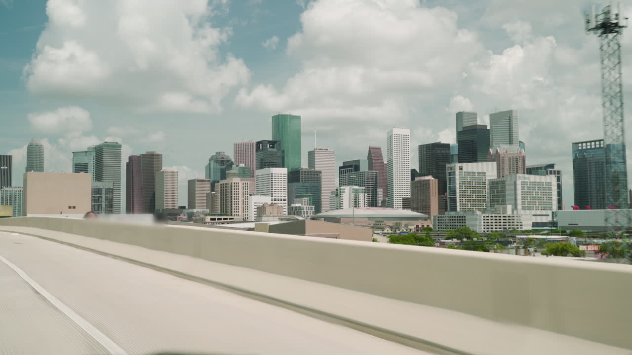 Revealing shot of the Houston Downtown on car. Driving to Downtown Houston. Driving on the freeway Downtown Houston in the background. Exit from I45 to I69 with the view of Houston Downtown.