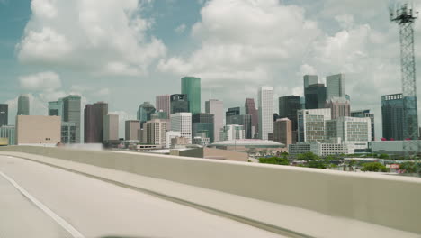 revealing shot of the houston downtown on car. driving to downtown houston. driving on the freeway downtown houston in the background. exit from i45 to i69 with the view of houston downtown.