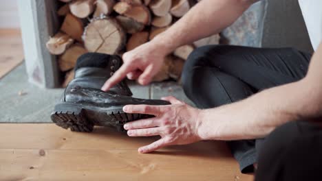 man polishes a black boot with one finger