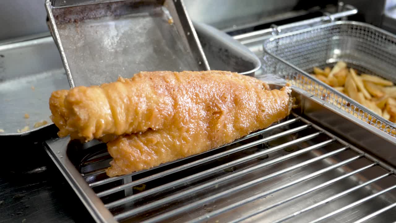 Freshly fried fish fillet served hot from the fryer at a local seafood restaurant in the afternoon