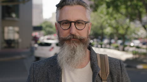 portrait of mature sophisticated bearded man wearing glasses staring contemplative looking at camera