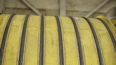 close-up of a yellow industrial winding drum with cables