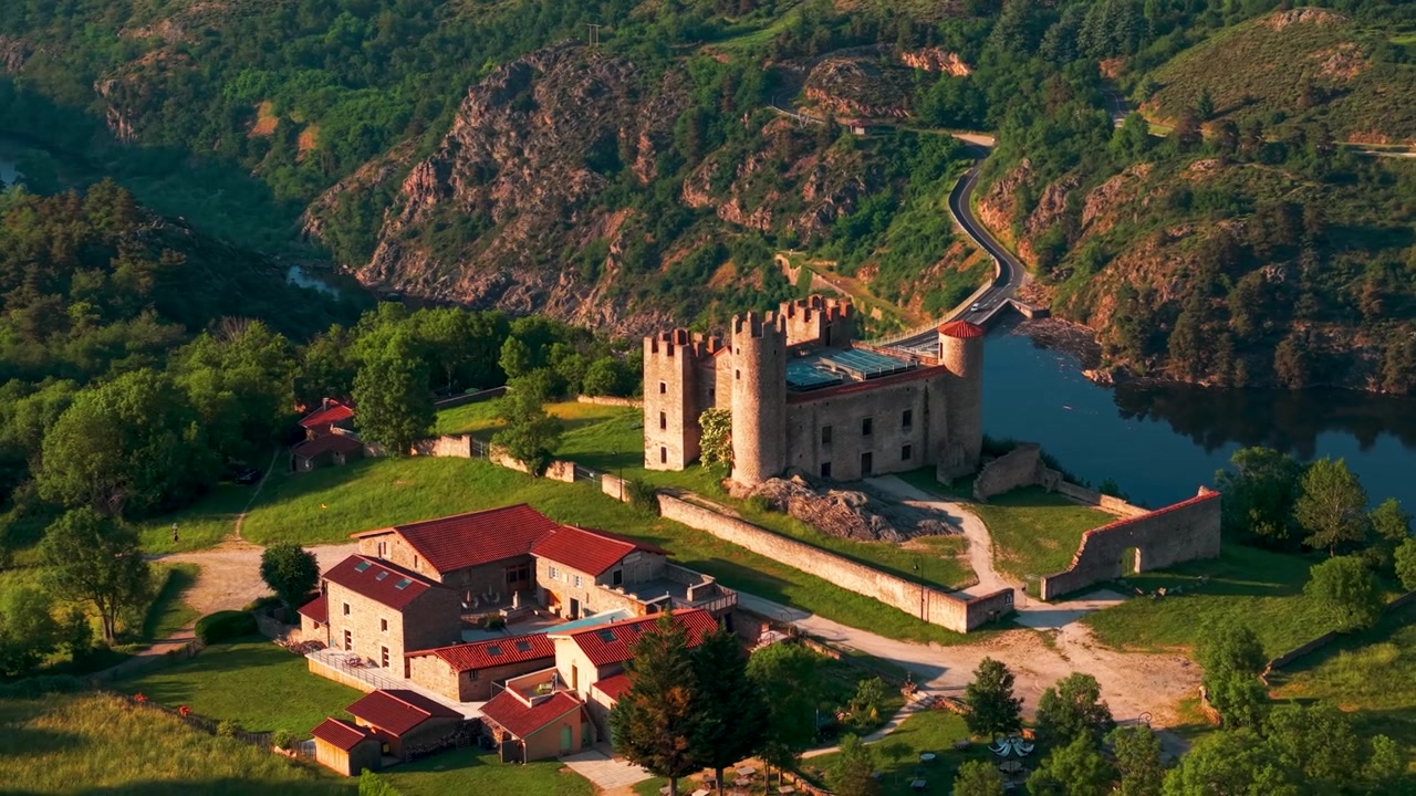 Ripresa aerea del Castello di Essalois vicino a Saint Just Saint Rambert al tramonto con il fiume Loira sullo sfondo, dipartimento della Loira, regione Alvernia-Rodano-Alpi, Francia