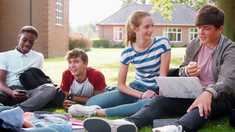 Teenage-Students-Sitting-Outdoors-And-Working-On-Project