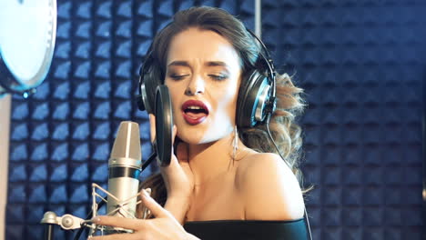 vinnitsa, ukraine - may 2019: audio recording studio. woman with headphones and studio microphone singing. slow motion