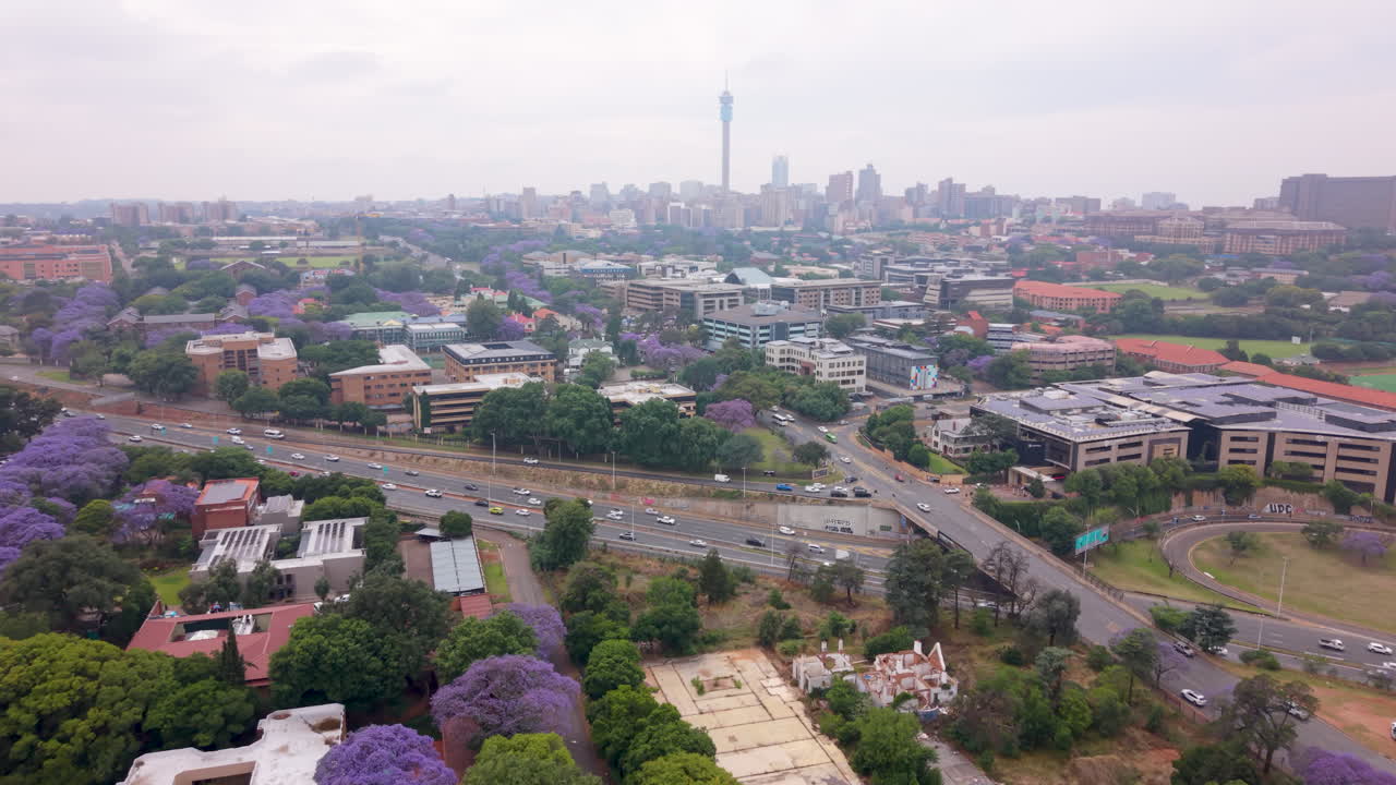 Aerial of morning traffic on Johannesburg N1 highway with Joburg city and Hillbrow in the distance on cloudy day
