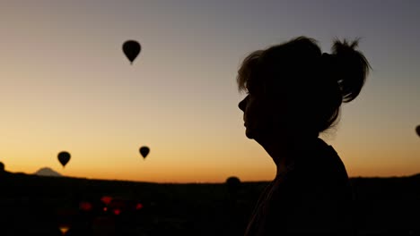 mujer silueta mira hacia el cielo amanecer vuelos de globo de aire caliente