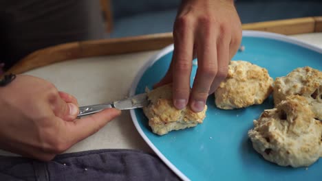 Slowmo---Kaukasischer-Mann-Schneidet-Frisch-Gebackenes-Traditionelles-Neuseeländisches-Scone