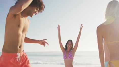 amigos de raza mixta bailando en la playa