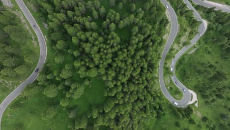 Una-Vista-Aérea-Captura-Los-Automóviles-Que-Atraviesan-Las-Carreteras-Serpenteantes-Cerca-Del-Paso-De-Selva-En-Los-Dolomitas,-Trentino,-Tirol-Del-Sur,-Italia.