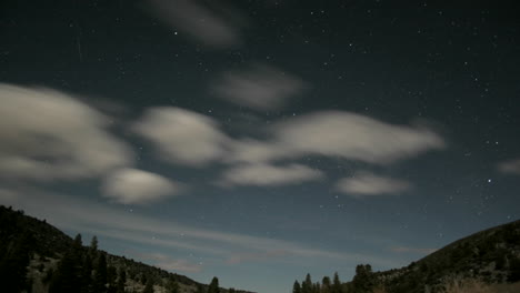 Fluffy-white-clouds-race-through-a-blue-sky-as-it-fades-into-darkness-then-returns-with-intense-light