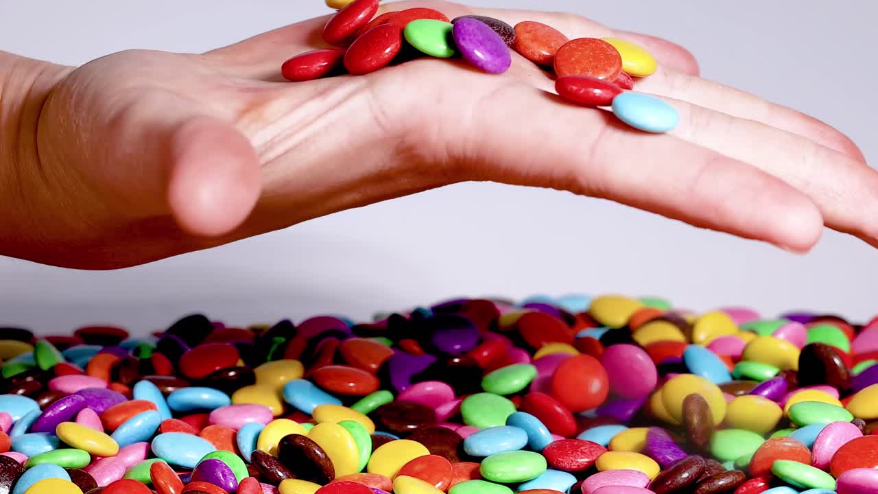 Hands engaging with a colorful assortment of candy, showcasing playful interaction and tactile exploration.