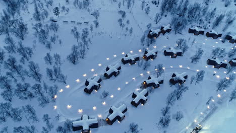 aerial top down shot of snowy snowhotel kirkenes and gamme northern lights cabins in norway