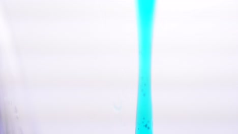 blue liquid pouring into a glass