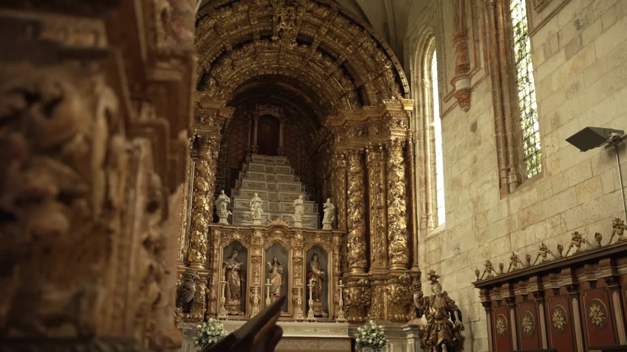 Exquisite gilded church altar with intricate carvings, statues, and tall arched windows