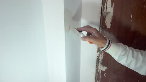 persona está haciendo ajuste fino de la pintura en la pared, sosteniendo la lámpara de luz de batería para hacerla más visible y más fácil de trabajar, artesanía y mantenimiento de la casa, concepto de reparación