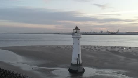 low tide aerial view coastal lighthouse sunrise shipping port cranes horizon wide left orbit