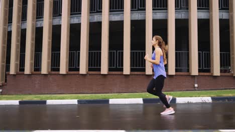 slow motion woman jogging against building