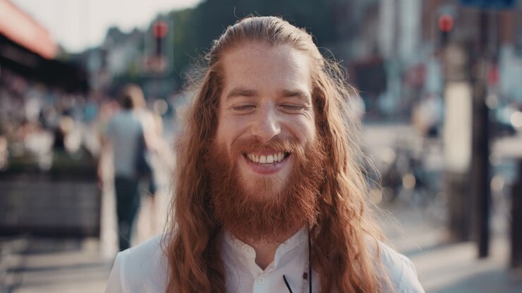 Zeitlupenporträt eines glücklichen Hipsters mit Bart, der lächelt