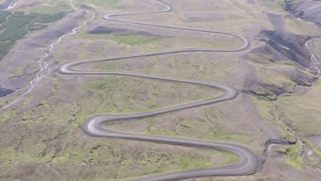 winding dirt road going downhill into valley of lake lagarfljót, iceland, aerial