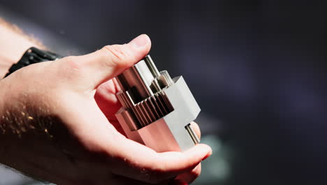 close-up of hands holding a complex metal component