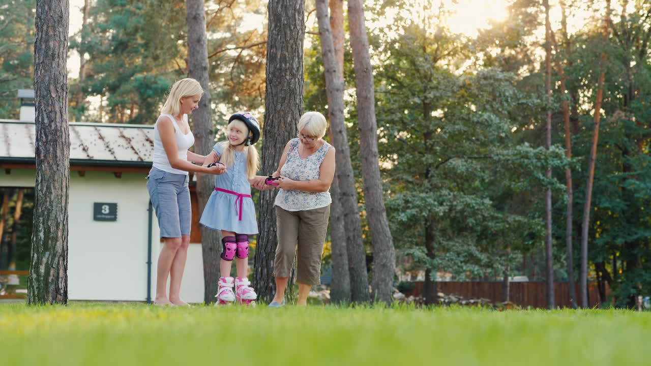 엄마와 할머니는 6세 소녀에게 롤러 스케이트를 타는 법을 배운다 - t