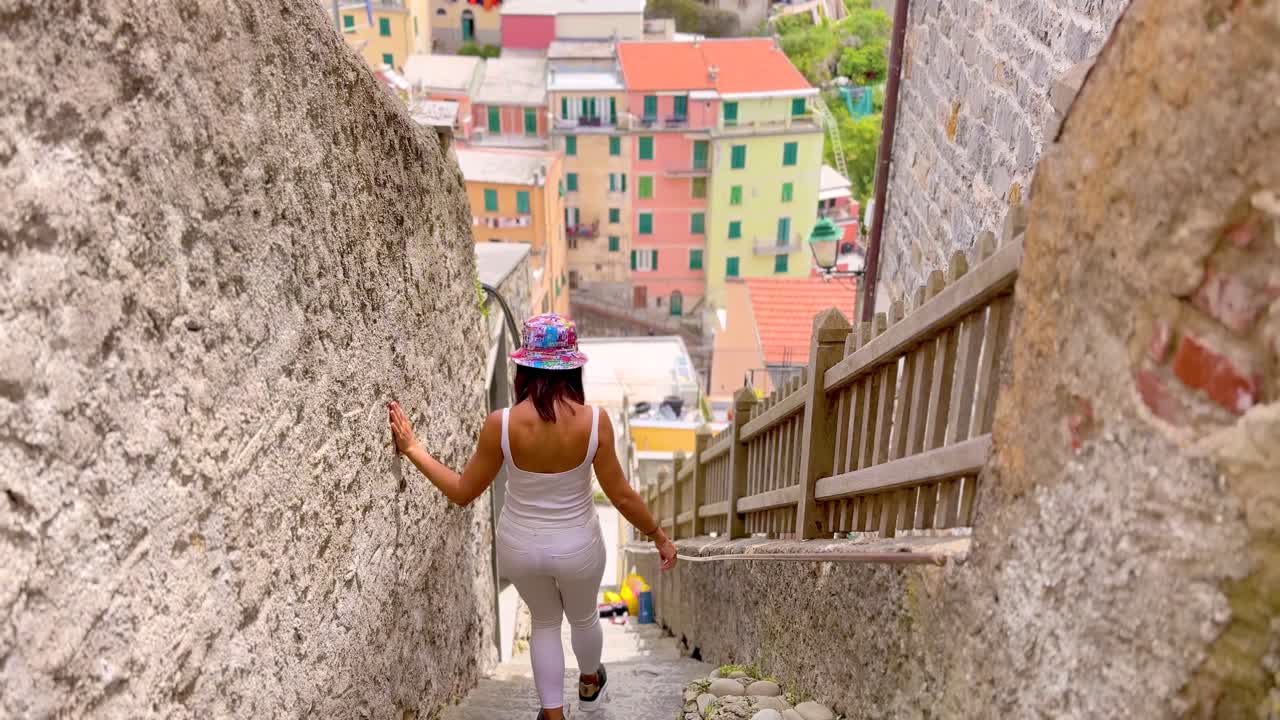 Young Woman Walking Through Picturesque Streets of Cinque Terre, Italy – Rear View in Colorful Mediterranean Village