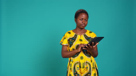 Natural-cute-girl-browsing-internet-on-a-tablet-against-blue-background