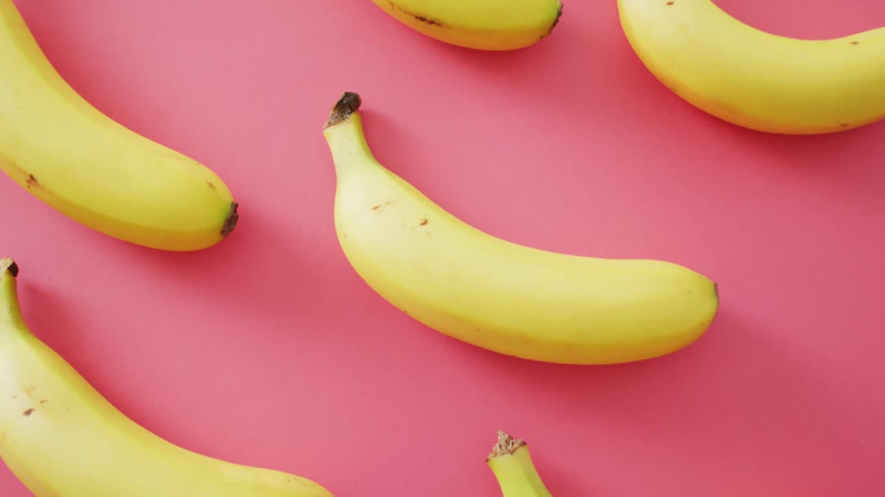 video de plátanos frescos sobre un fondo rosa