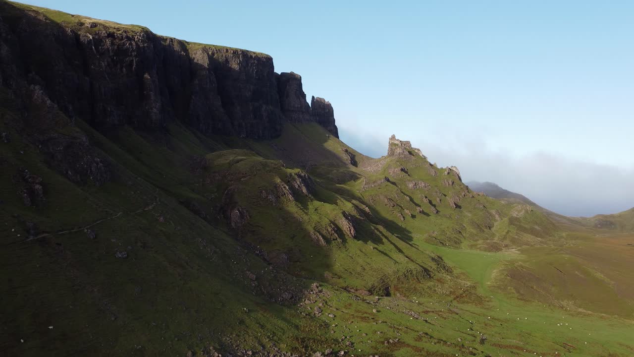 공중 드론은 푸른 파노라마 절벽 위를 날아다니며 여름에 스코틀랜드의 스카이 섬의 라링에서 트레킹합니다.