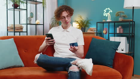 hombre usando tarjeta de crédito bancaria y teléfono inteligente mientras transfiere dinero compras en línea compras en casa