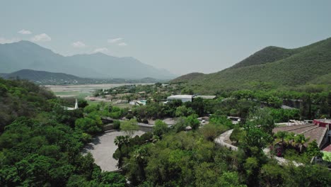 AERIAL---City-and-surrounding-mountains,-Santiago,-Nuevo-León,-Mexico,-forward