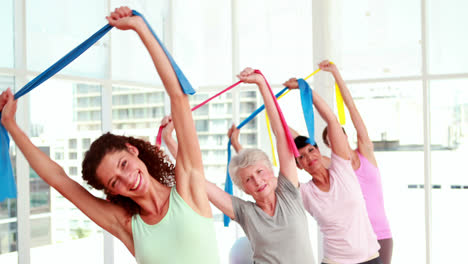 Mujeres-Estirando-Bandas-De-Resistencia-En-Una-Clase-De-Fitness