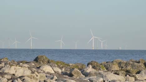 Turbinas-De-Utilidad-De-Molino-De-Viento-En-Alta-Mar-De-Energía-Alternativa-Que-Giran-En-El-Horizonte-Del-Paisaje-Marino