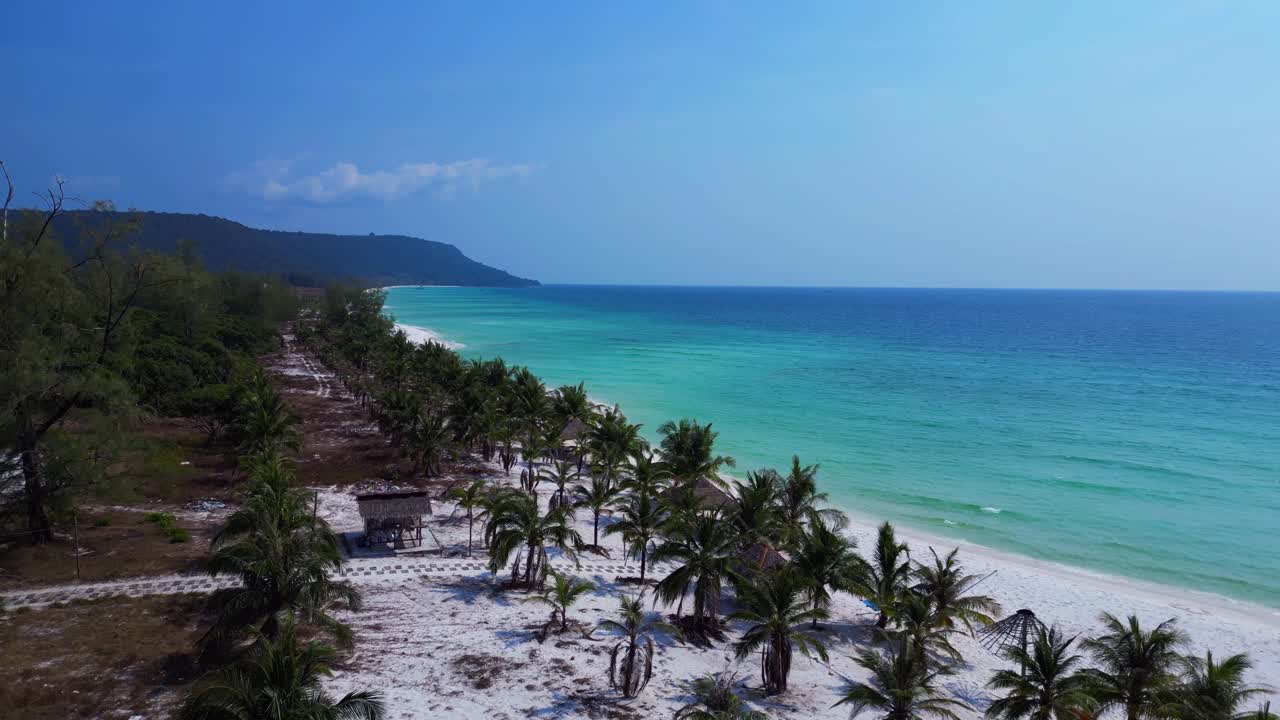 Sok San Beach with turquoise water washing the white sand, surrounded by palm trees and tropical vegetation. Fantastic aerial view flight overflight flyover drone