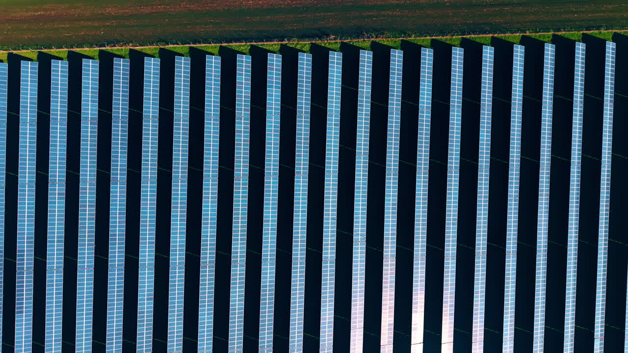 Grandi siti di celle fotovoltaiche lunghe installate in campagna. Concetto di energia rinnovabile. Vista dall'alto