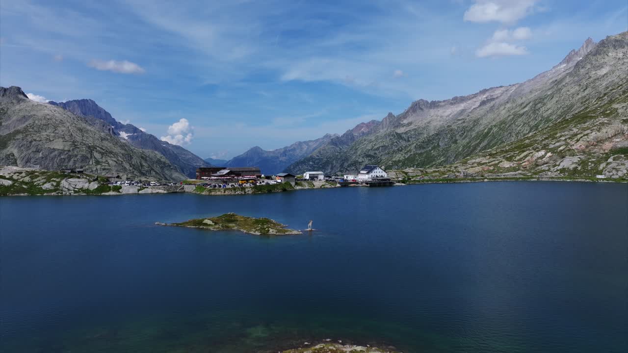 Aerial View of Totensee Lake surrounded by majestic Swiss mountains under a blue sky. Captures Switzerland's breathtaking natural beauty, serene water surfaces, and rugged mountainous terrain.