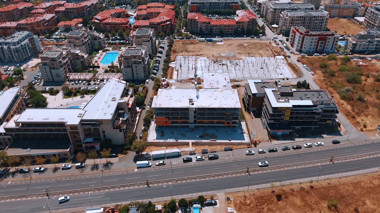 Modern seaside construction site. A large building under construction near the coastline with cranes and equipment