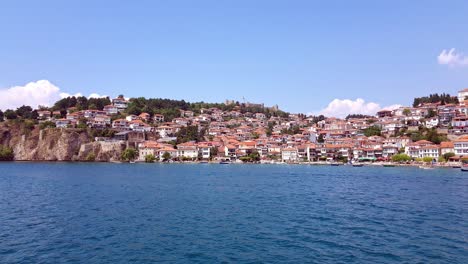 beautiful view of ancient ohrid city and buildings on harbor from boat on water perspective