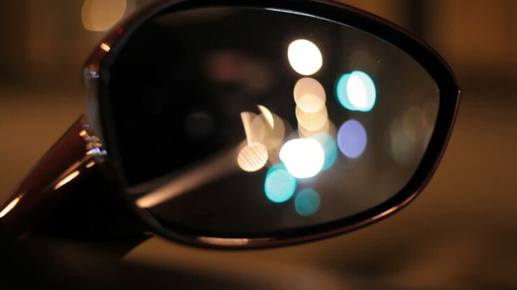 Night city in car rear view mirror. Reflection street lights. Automobile mirror