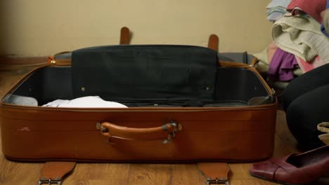 woman packing old brown suitcase time lapse