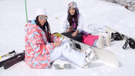 two attractive women snowboarders relaxing