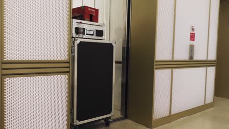 man pulling flight cases and boxes into an elevator for a live streaming event