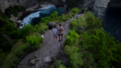 Drohnen-Schwenk-über-Paar-Am-Aussichtspunkt-Zeigt-Malerischen-Diamond-Beach,-Nusa-Penida